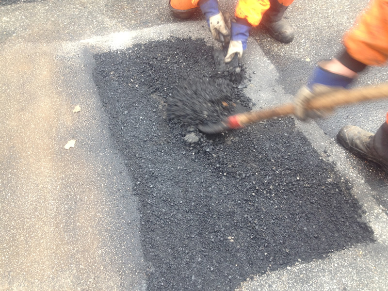 Den beschädigten Asphalt nach der Erwärmung ausbauen.